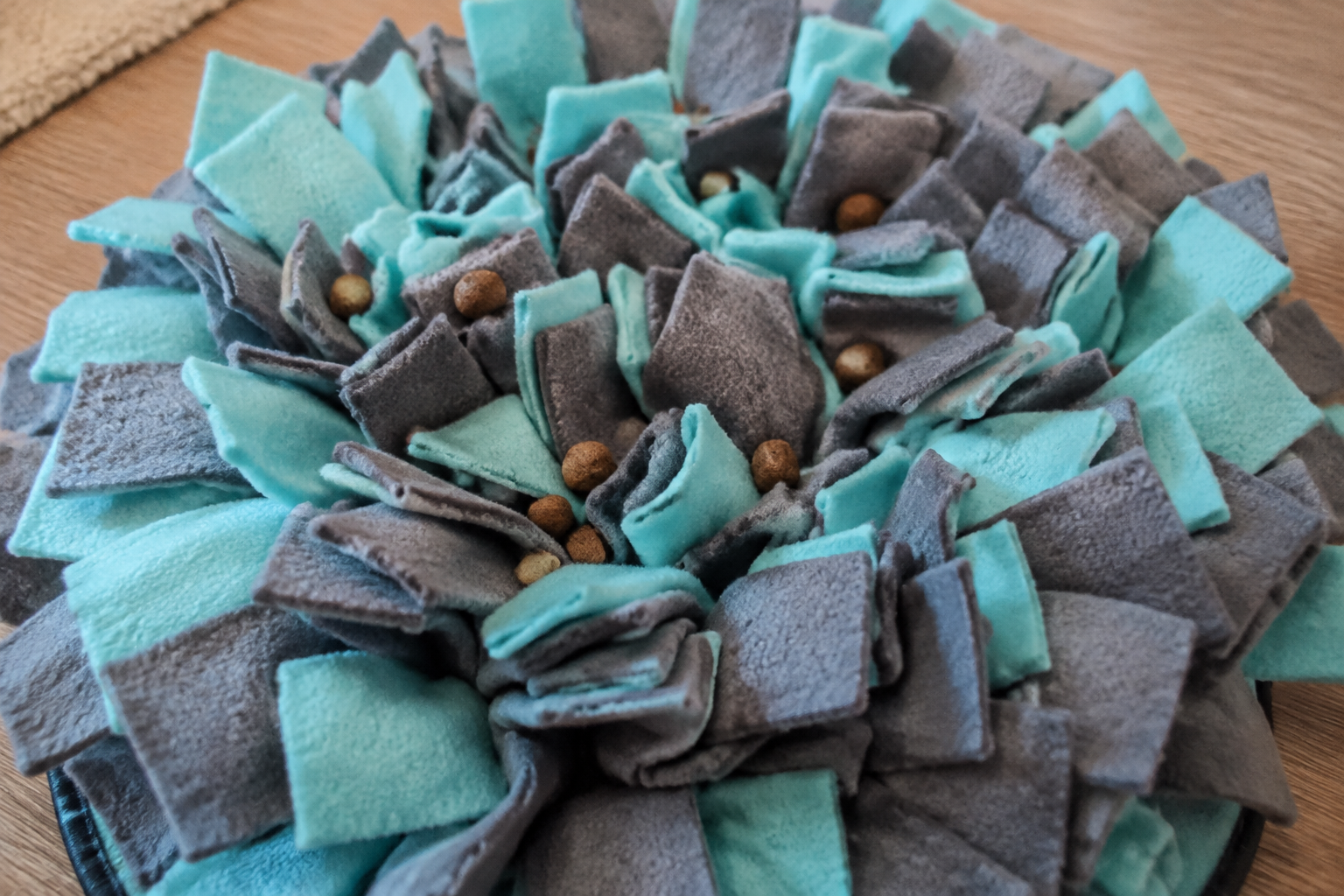 Illustration of a fabric snuffle mat with a few pieces of food visible on top.